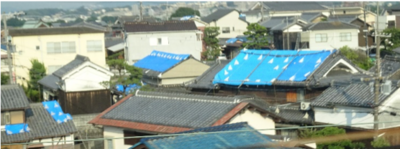2018年6月の大阪北部地震で被災した、ブルーシートで覆われた民家の屋根