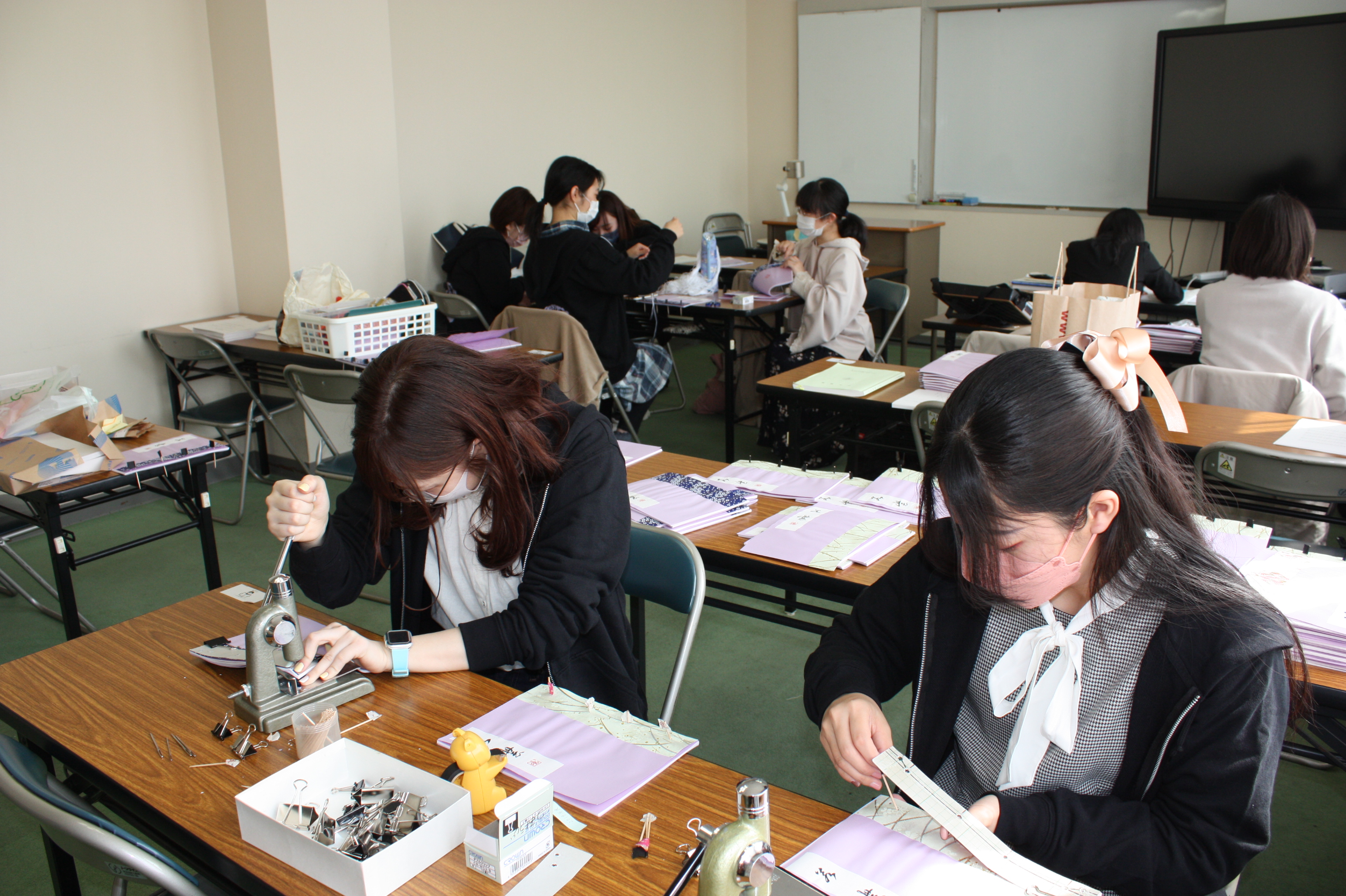 機械で穴を開ける学生たち