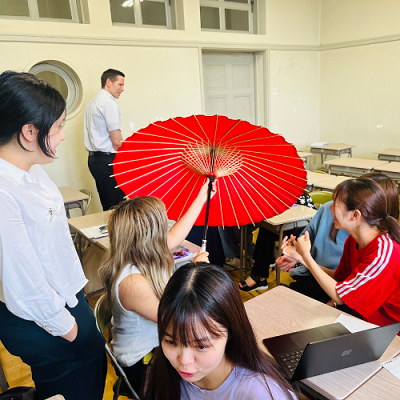 「英語Ⅰ」の授業での交流の様子 サークル活動についても触れながら大学生活を紹介したプレゼンテーション