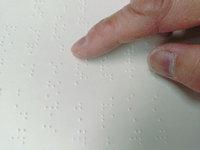 写真2　点字を指で触る様子（筆者撮影）