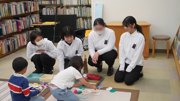 子どもたちと折り紙で交流する学生たち