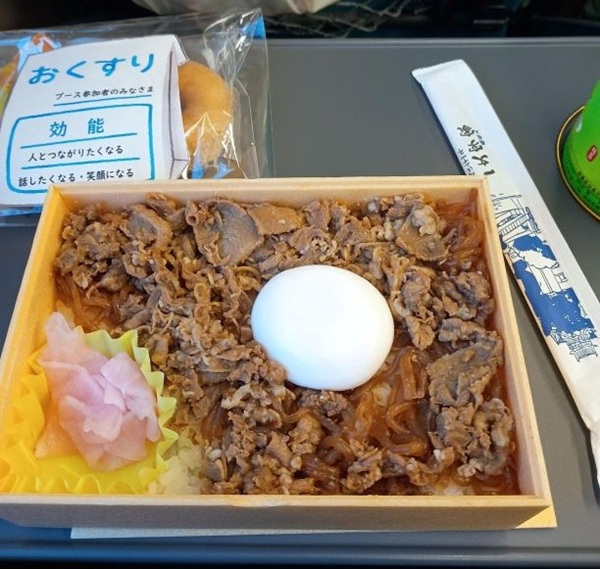 帰りの「やくも」号の車内にて。左上に見えるのは、分科会ブースで貰った記念品です。人とつながることは、今回の参加目的でもあり、このフォーラム自体の目的でもありました。(学生提供)