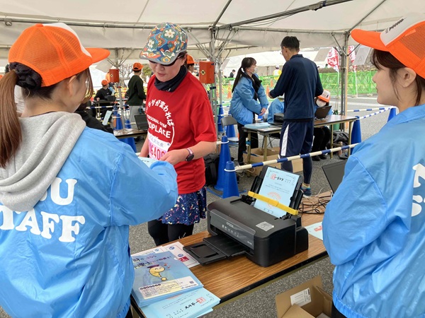 完走証をランナーへ手渡す